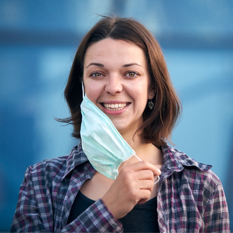 A woman smiling with a mask