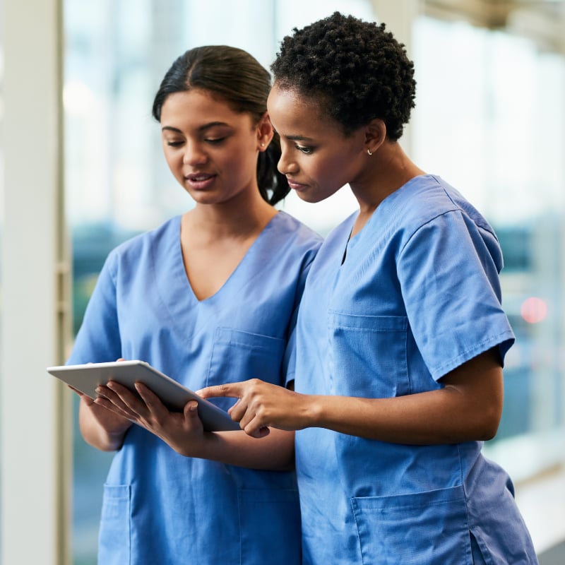 Two female physicians discuss a medical chart