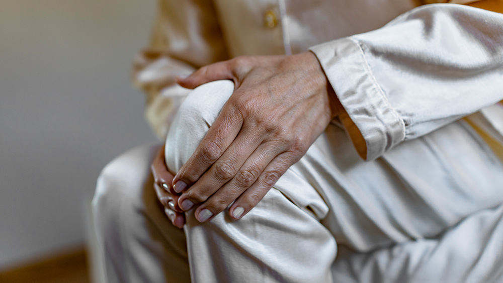 Older adult holding knee in pain
