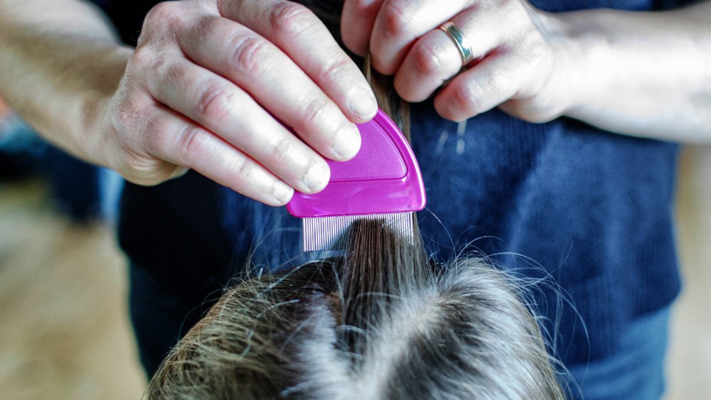 A mother combing a child's head and checking for head lice