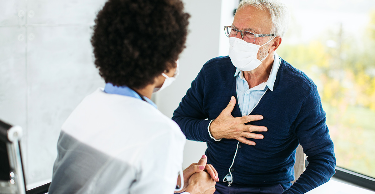 Female doctor examining senior male patient in a modern office clinic