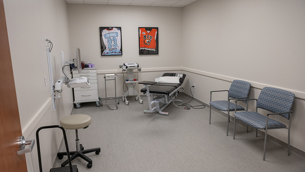 Patient room with a bench chair and two framed jerseys on the wall