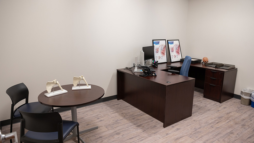 Medical provider office with white walls a wooden desk and computer