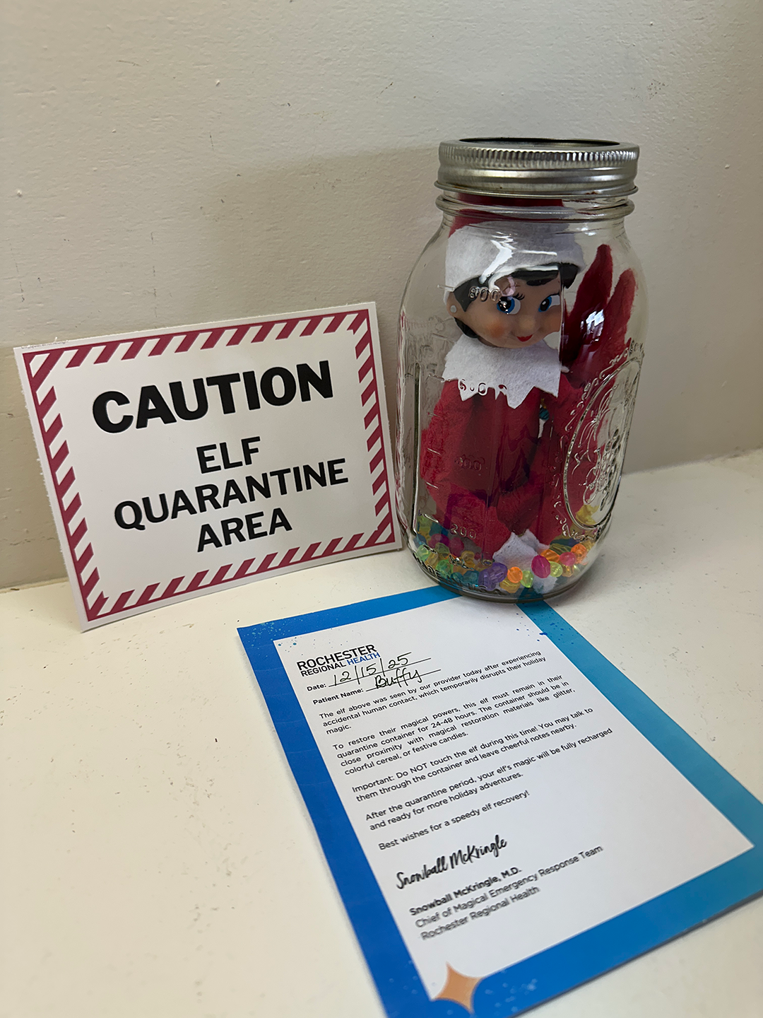an elf-on-the-shelf in a glass jar in quarantine
