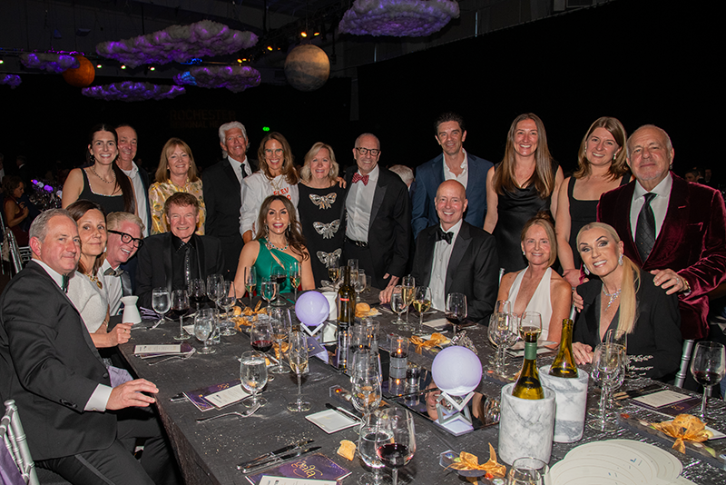 Group of gala attendees standing and smiling for photo