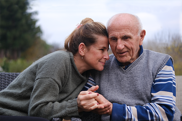 A dad and a daughter in long sleeve shirts hold hands outdoors