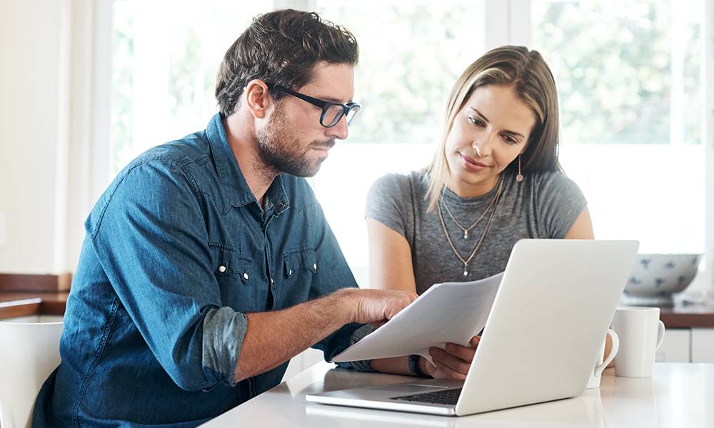 a couple of people looking at insurance plans online