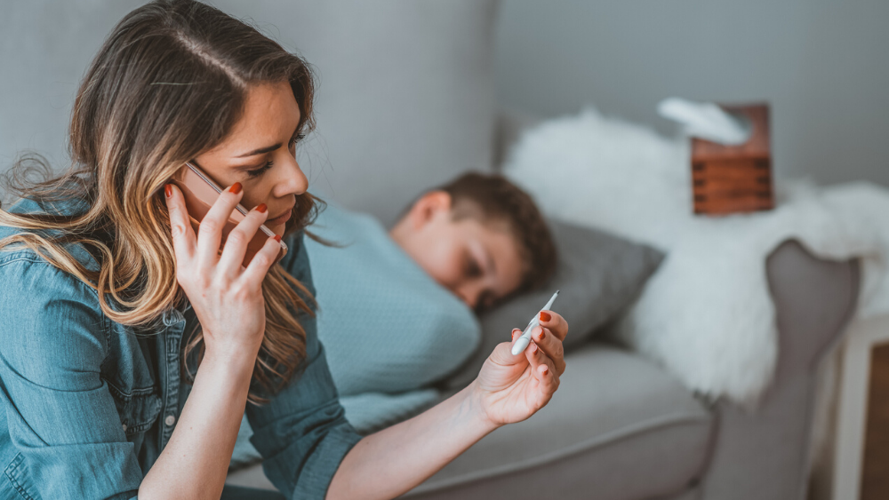Mother checking child's temperature for coronavirus or flu