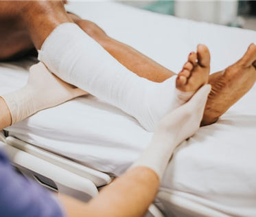 a healthcare professional moves a patient's leg in a cast