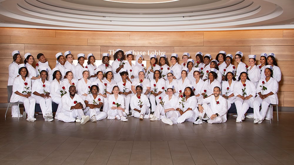 Group of nursing graduates in nursing caps and white coats