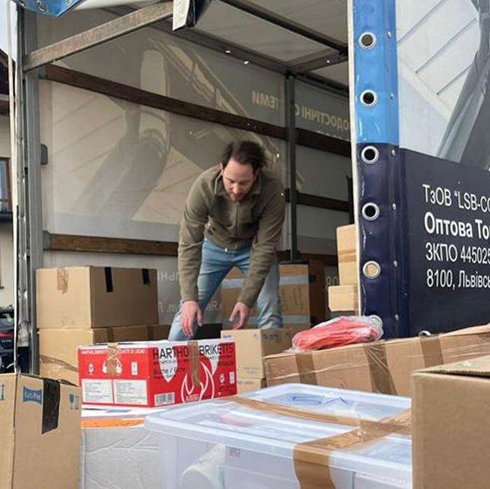 A Rotaract member organizes supply boxes at a transit station while coordinating Ukraine war relief efforts.