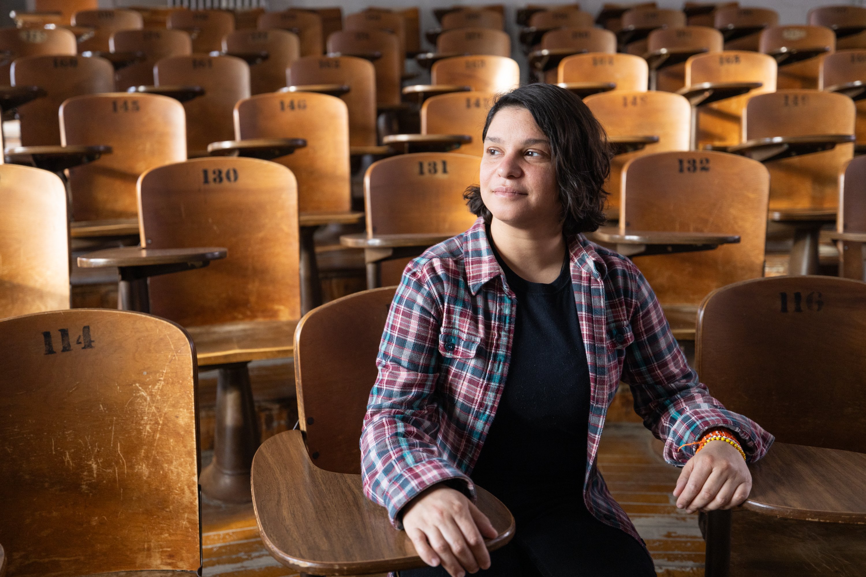 Conservation scientist Gabi Fleury sits in numbered auditorium seats at the University of Wisconsin-Madison.
