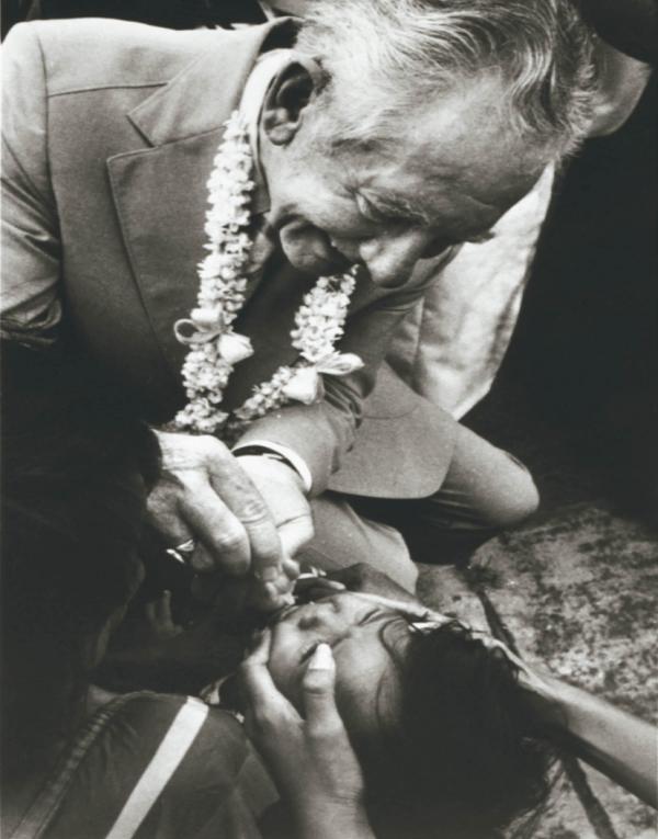 Rotary member gives a child an oral polio drop in the Philippines.