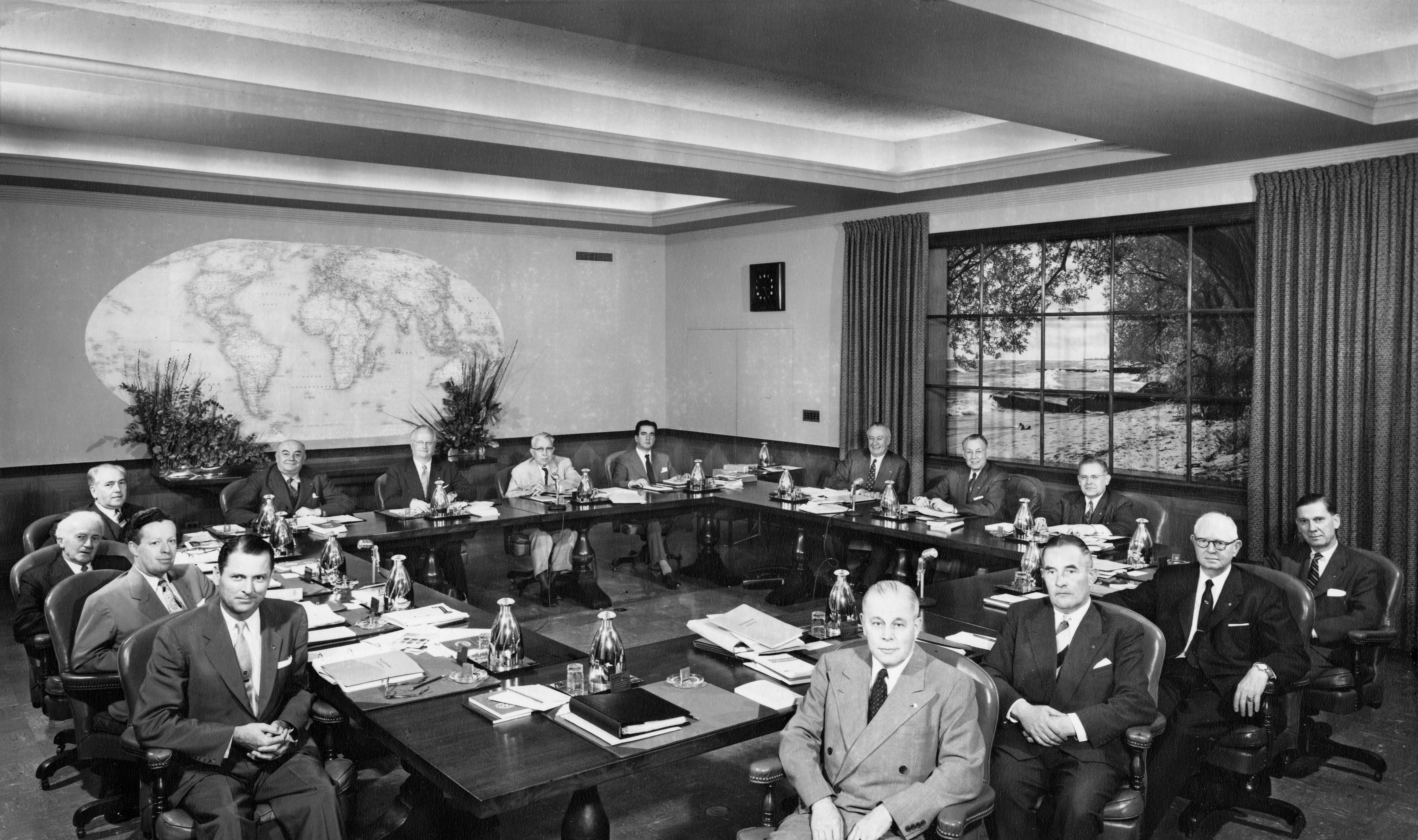 The 1955-56 Board of Directors. Clockwise from bottom left: Dan Procter, Kenneth G. Partridge, Spencer J. Hollands, Alejandro Garreton Silva, Alphonse Fievez, Allin Winston Dakin, Joseph A. Abey, Ernesto Imbassahy de Mello, O.D.A. Oberg, A.Z. Baker, George R. Means, Roy D. Hickman, W.B. Todd, C.P.H. Teenstra, Herbert J. Taylor.