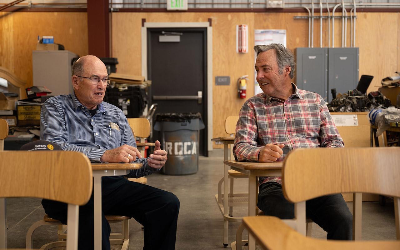 Os rotarianos Ric Masten (à esquerda) e Mark Grandcolas estão sentados em uma sala de aula e conversam no Rancho Cielo.