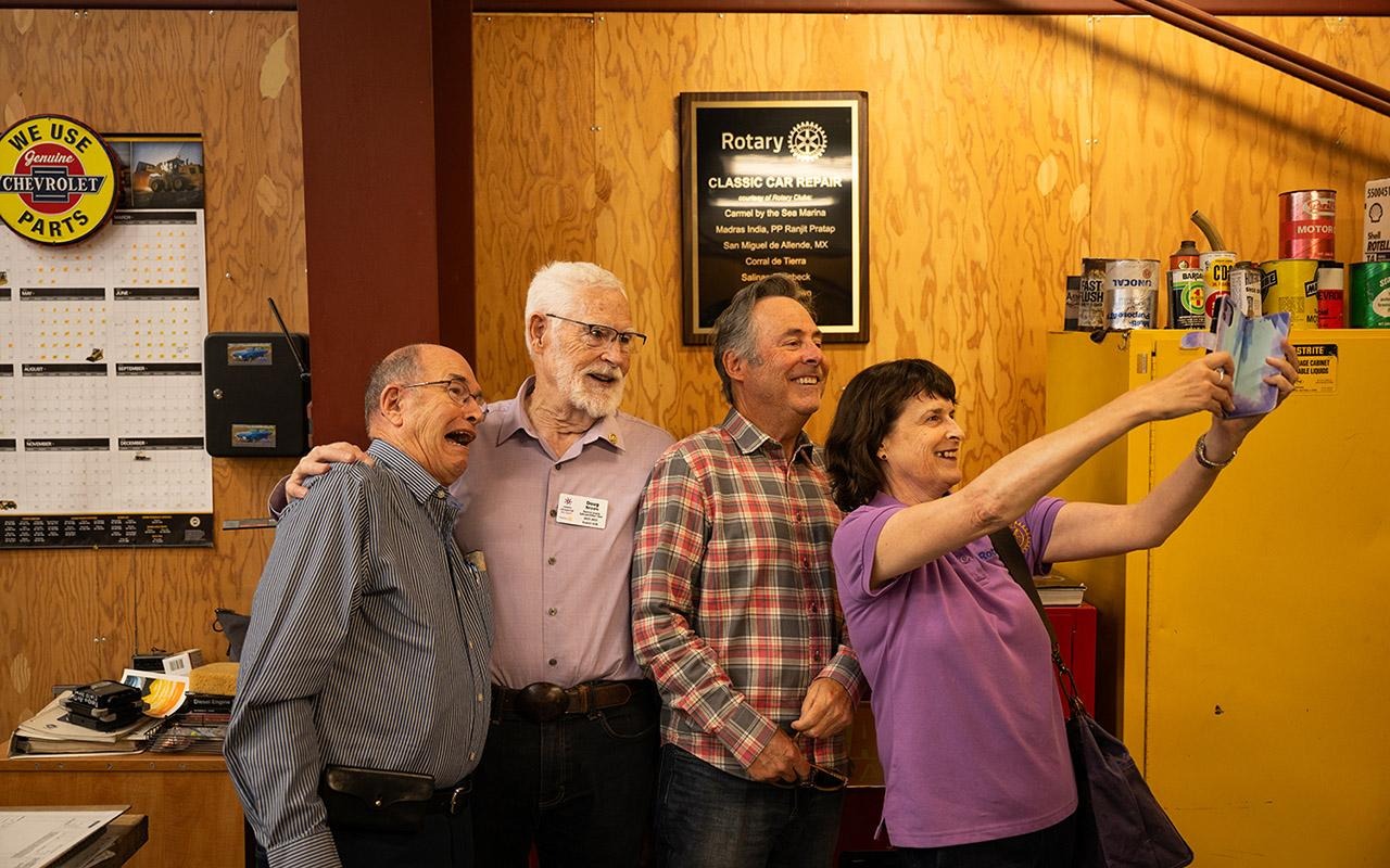 Quatro associados do Rotary posam para uma selfie durante um workshop. 