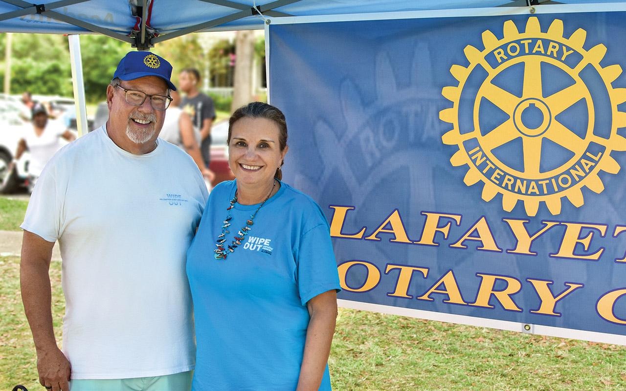 Scarinci right and Butch Busby standing in front of the Rotary Club of LaFayette banner.