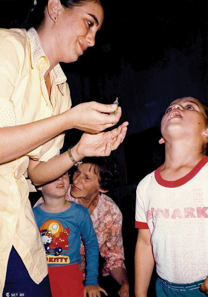 Scarinci in 1985 administers polio vaccine to children in Brazil.