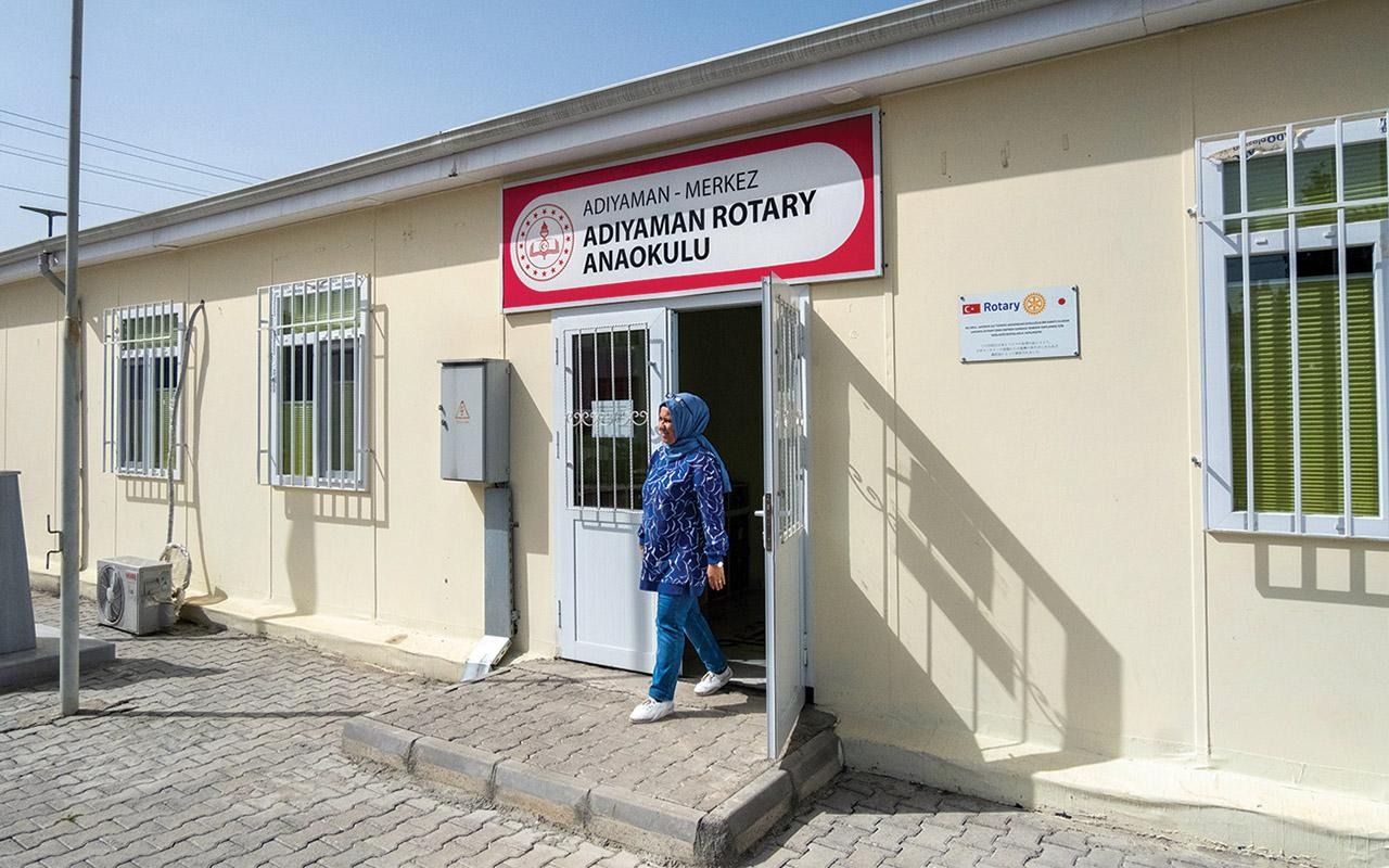 Principal Zeliha Özlem Atlı exiting a building with signs reading “ADIYAMAN ROTARY ANAOKULU” and “ADIYAMAN - MERKEZ.