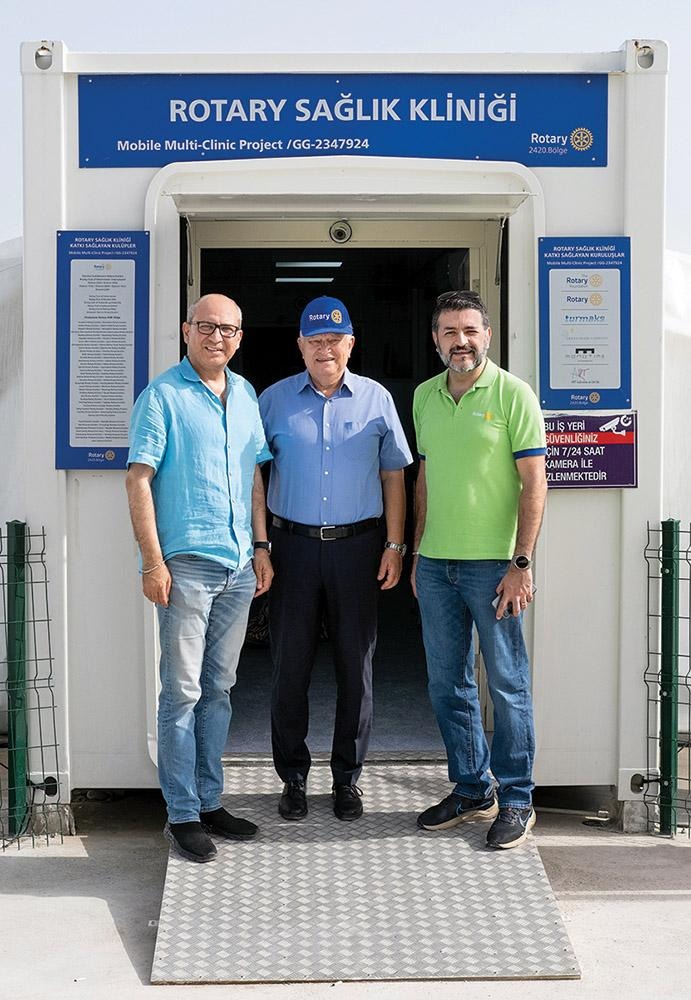 (From left) Ferit Binzet, Suat Baysan, and Emre Öztürk standing outside the Rotary Sağlık Kliniği mobile health clinic entrance.