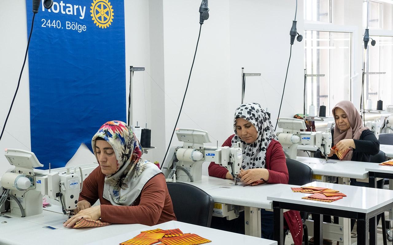 Three women sewing fabric at sewing machines in a workshop with a Rotary 2440.