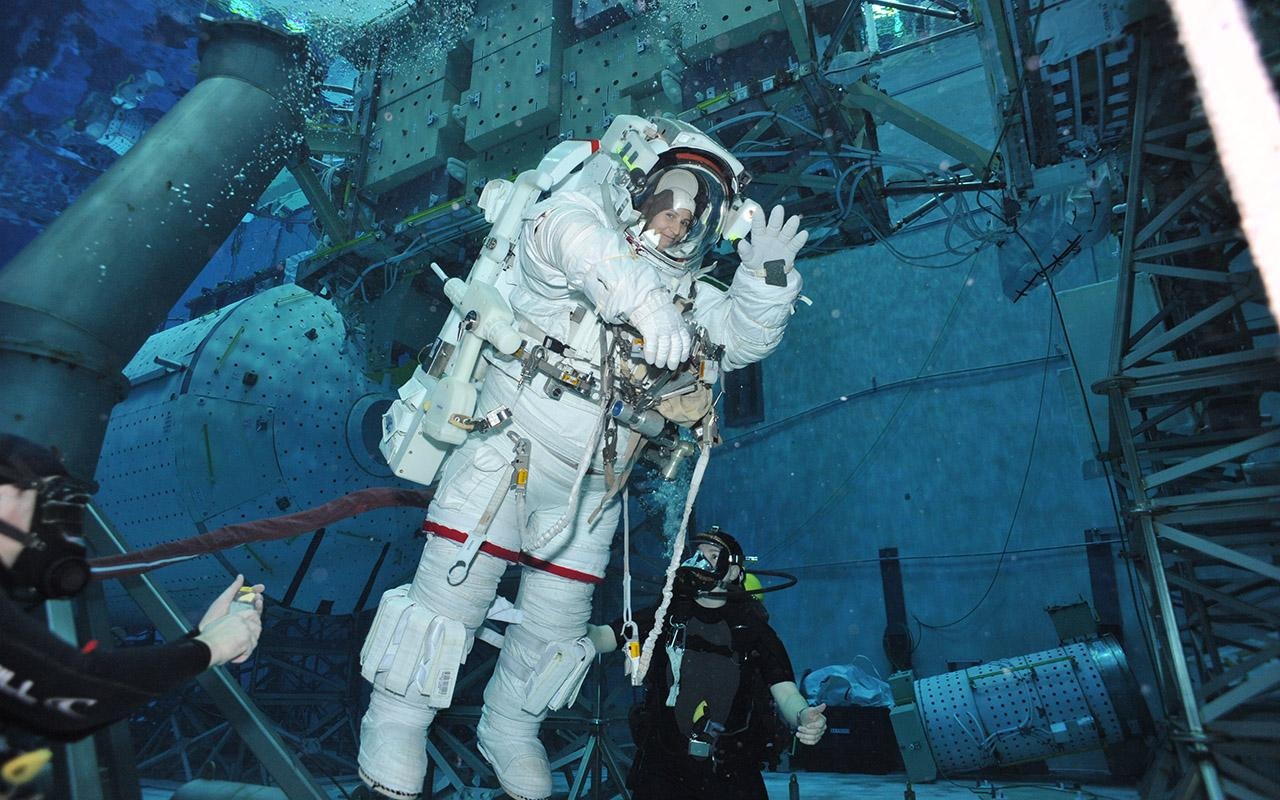 La astronauta Samantha Cristoforetti flotando bajo el agua durante un entrenamiento para una caminata espacial en una piscina grande.