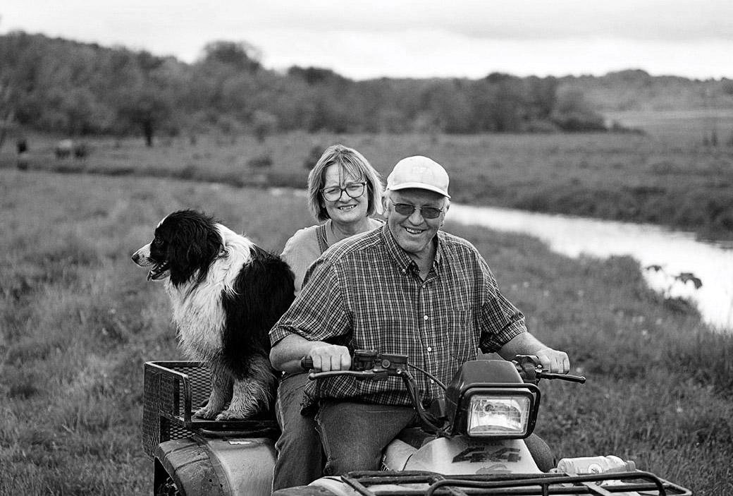 Dorothy and Don Harms with their dog Max in the pasture to move beef cattle.