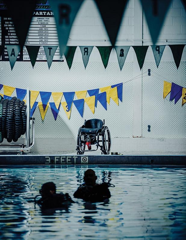 People standing in an indoor pool while participating in a scuba diving training session.