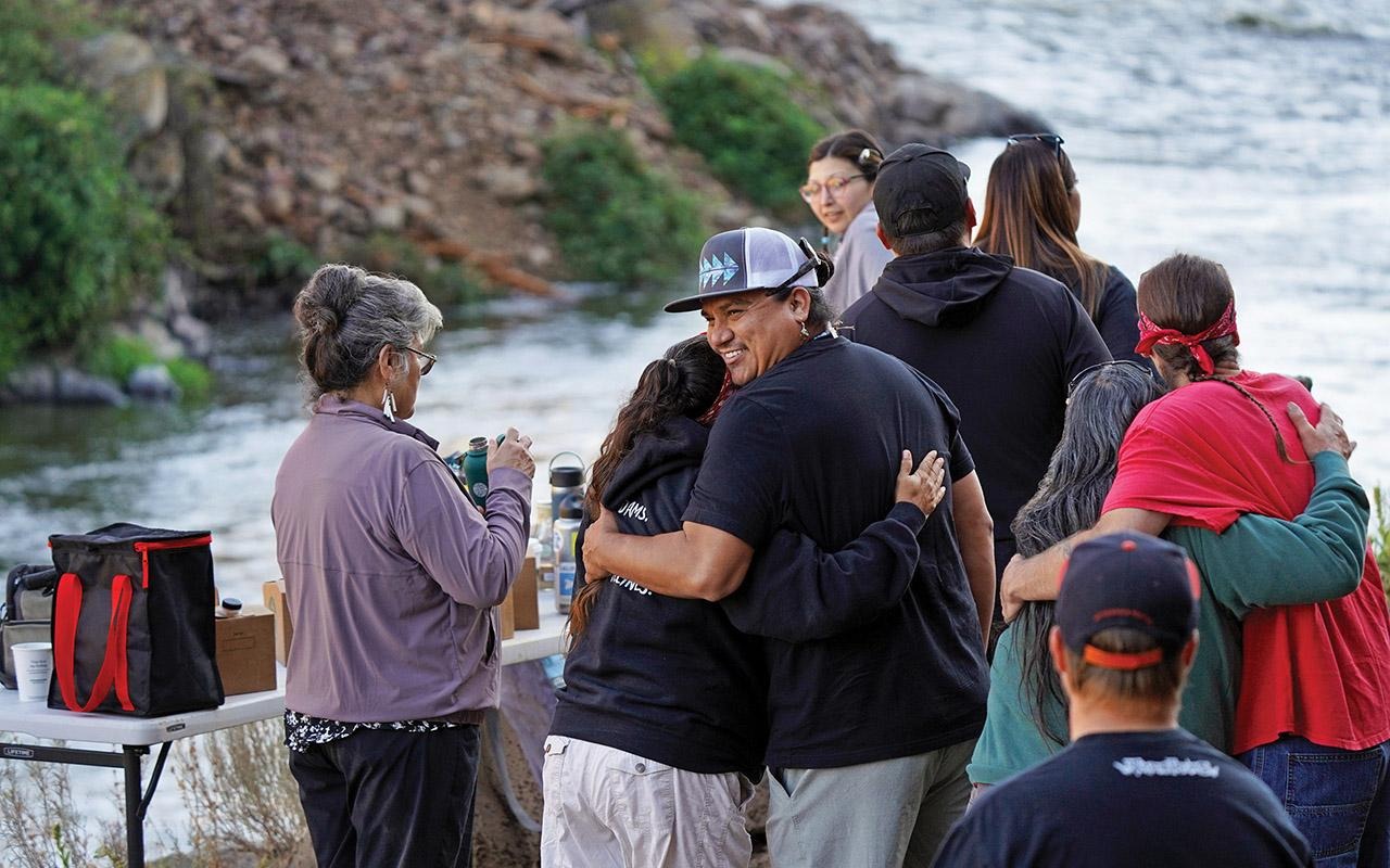 Onlookers embracing as crews remove the last portion of the Iron Gate Dam in August 2024.