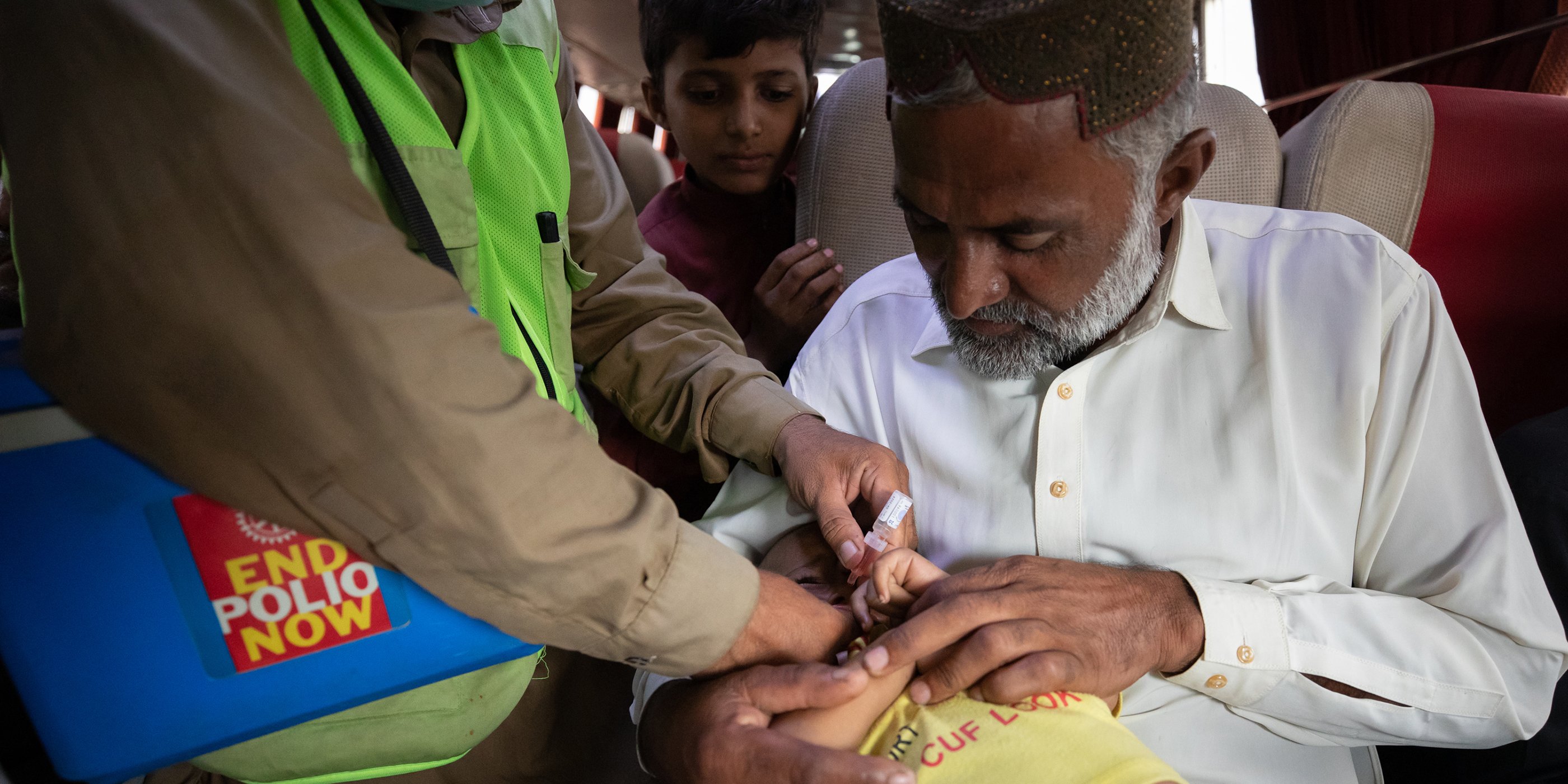 A health worker vaccinates a child on a bus at Karachi Toll Plaza, a permanent transit post (PTP) in Karachi, Pakistan.
