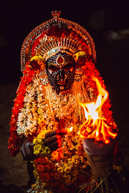 Un ballerino mascherato si esibisce durante un rituale Bhuta Kola a Puttur, in India