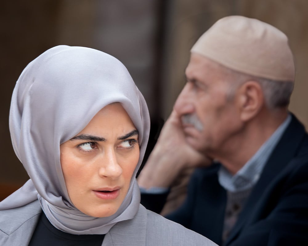 Una donna attraversa il cortile della moschea di Gazi Husrev-beg, risalente al XVI secolo, nel cuore della storica zona del mercato di Sarajevo, risalente all'epoca ottomana