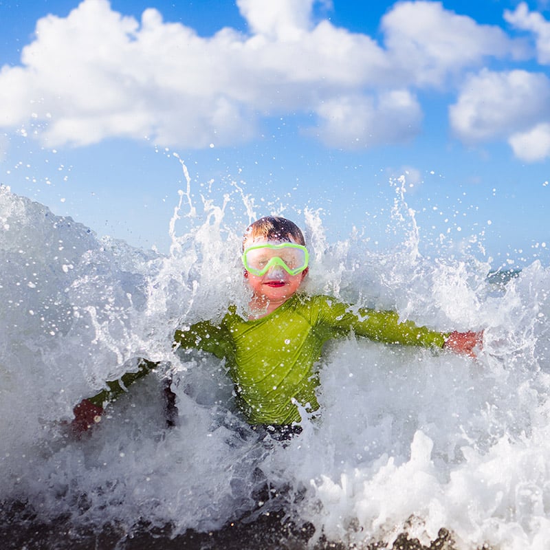 Un ragazzino sguazza nell'oceano