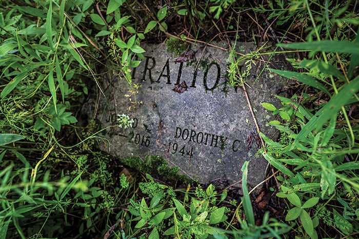 Gravestone partially covered by grass with the visible text “Dorothy” and “Kralov.”