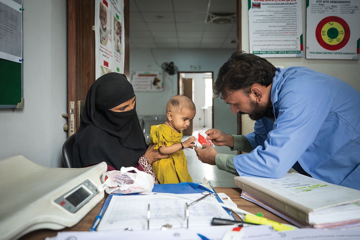 A health worker with a woman and her child
