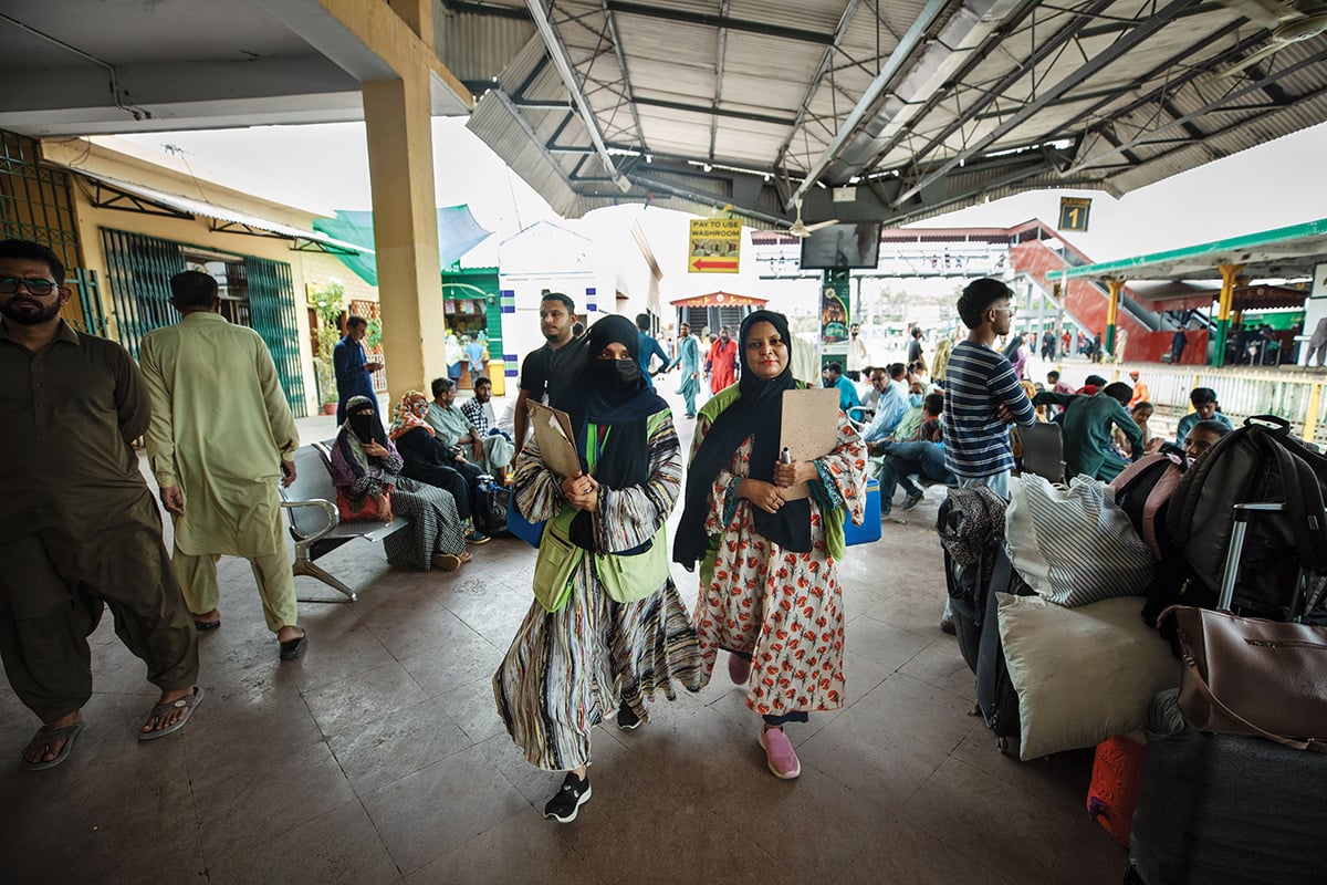 Healthcare workers walking through a public transit station