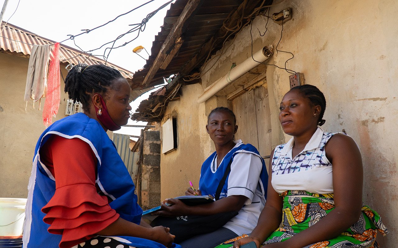 Faith Gideon and Judith Anyah using a tablet while speaking with two seated people outside a building. Provide your feedback on BizChat