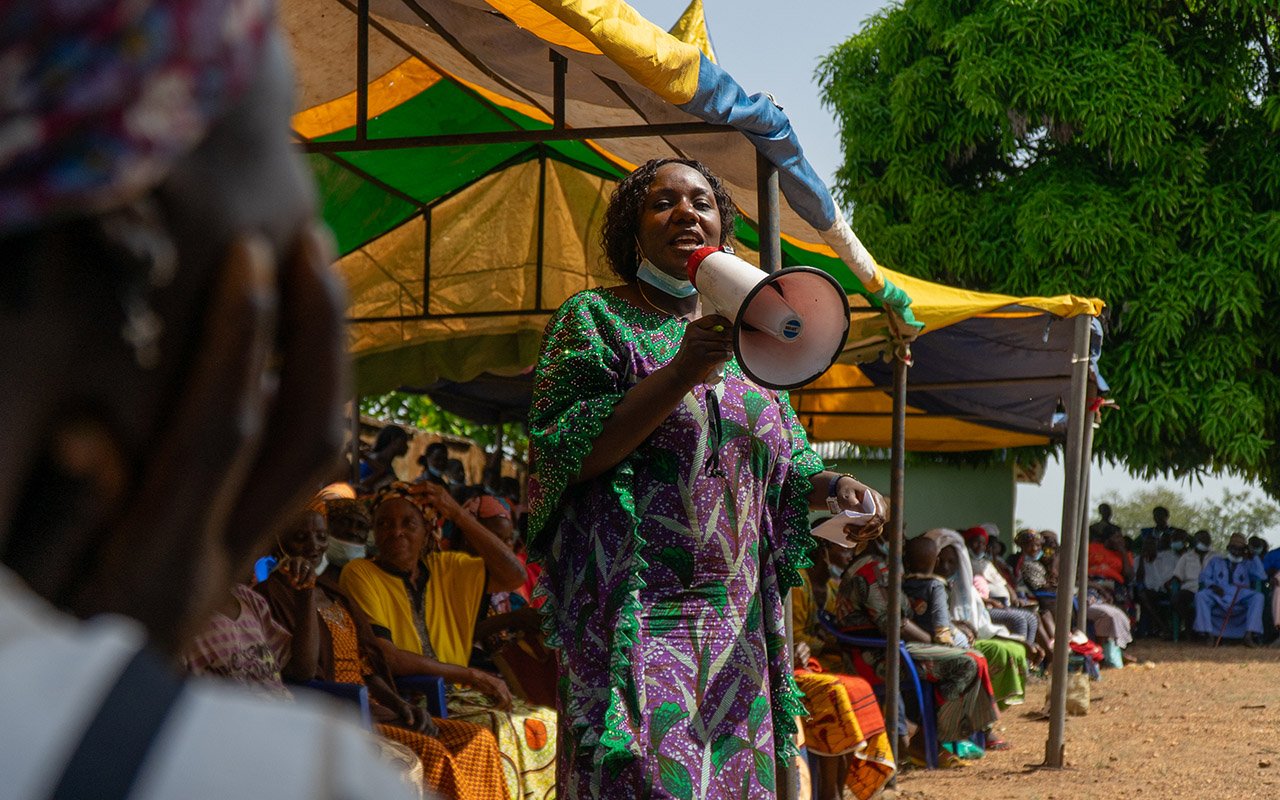 Ashezi David Alu speaks with a megaphone at a community dialogue at the Gwanje Primary Health Centre.