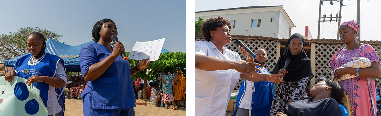 Person speaking into a microphone while holding a paper beside another person carrying blue balloons, next to a community health interaction outdoors.