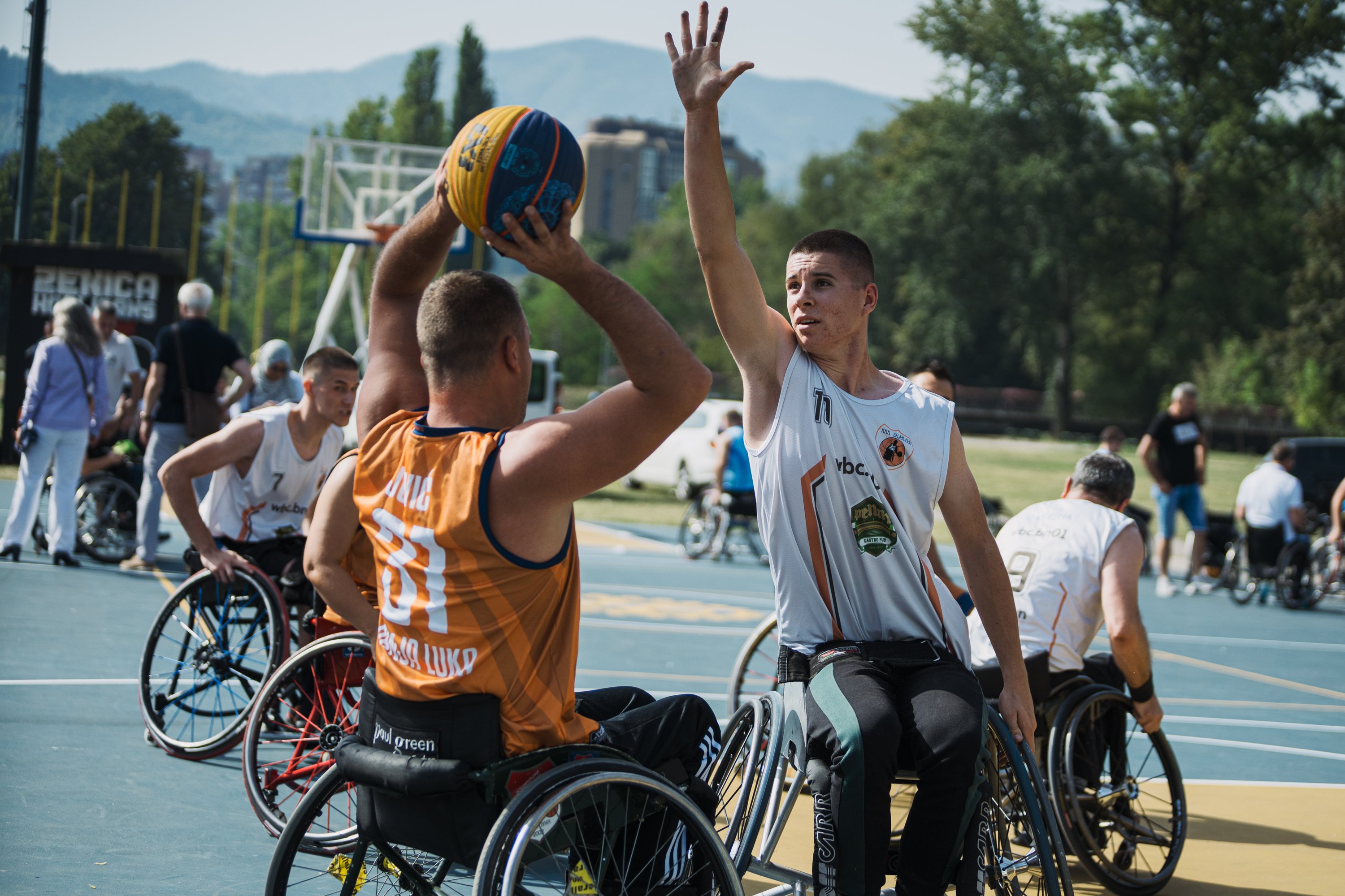 Os jogadores disputam uma partida de basquete em cadeira de rodas no Parque Kamberovića, em Zenica, na Bósnia, durante um projeto de inclusão para pessoas com deficiência apoiado pelo Rotary.