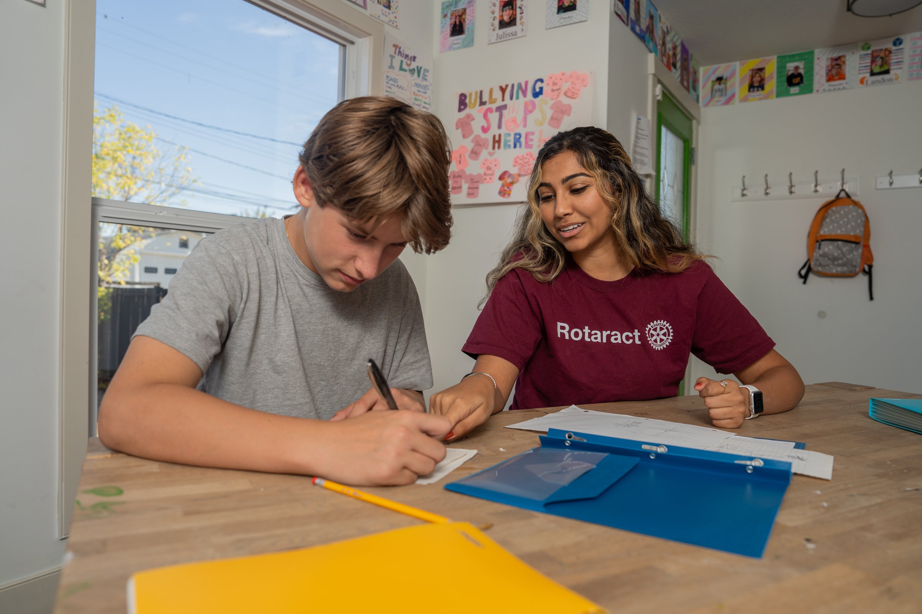 Um voluntário do Rotary ajuda uma criança com os deveres escolares na Marmie’s House, em Calgary, um programa de atividades extracurriculares seguro para jovens carentes.