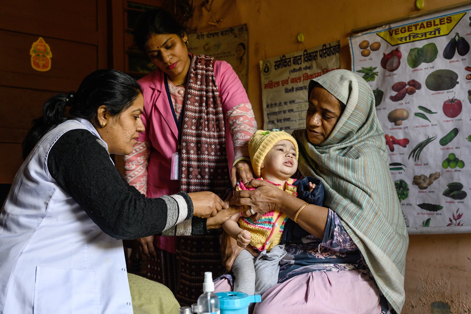 A health worker administers a vaccine to a young child.