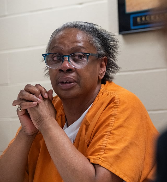 A female inmate sits as she is being interviewed