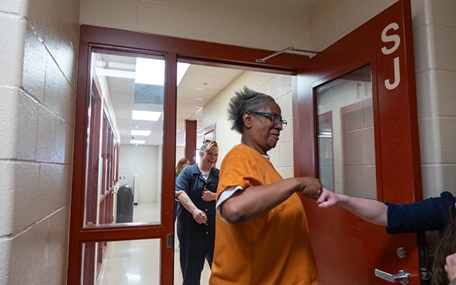 A female inmate interacts with prison staff