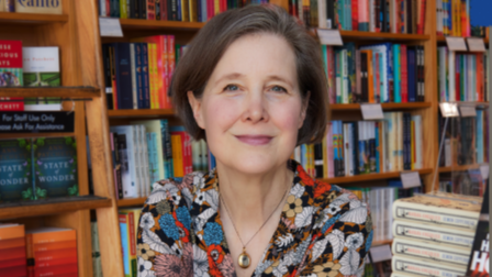Portrait of Ann Patchett in front of a large bookcase.