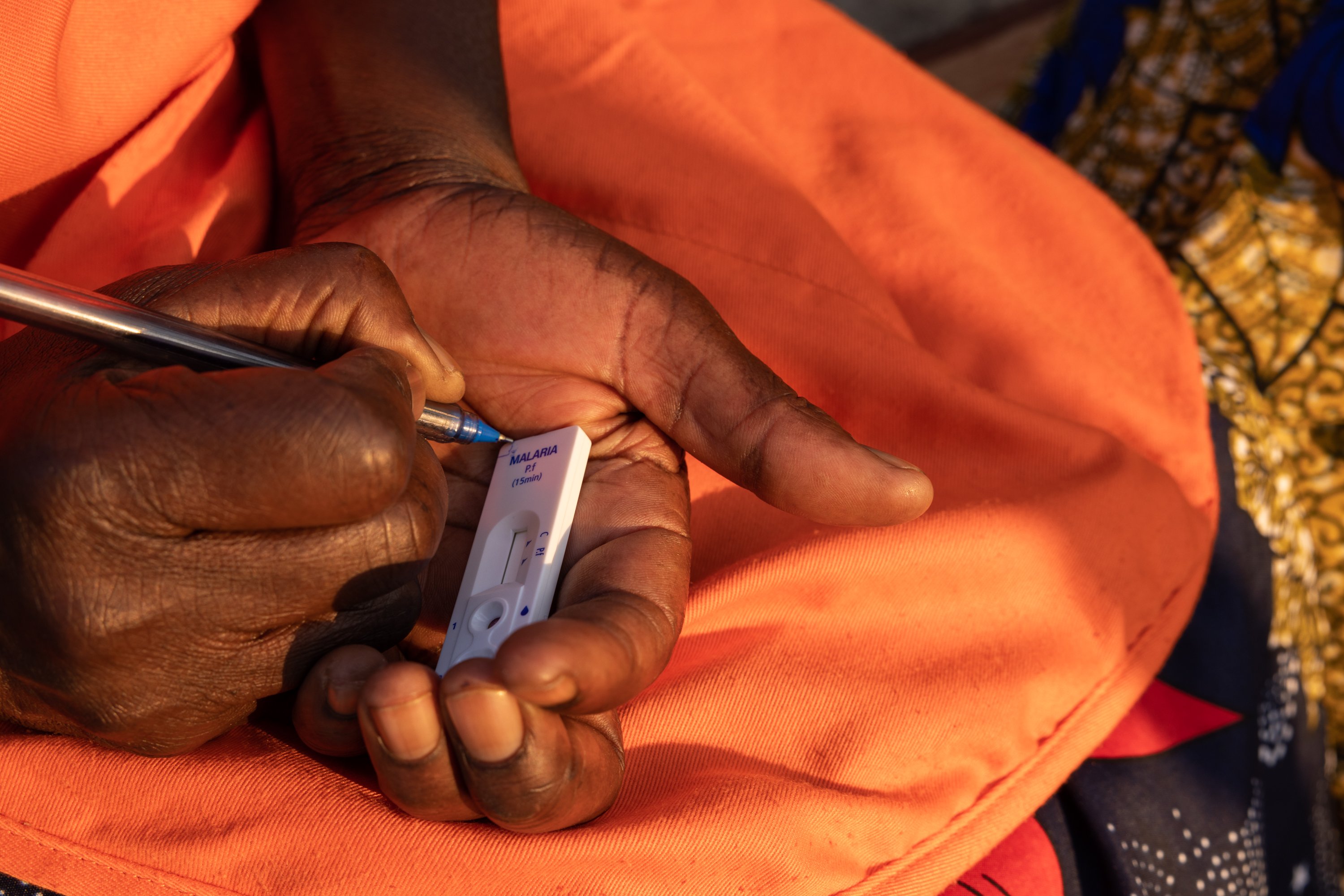 A community health worker demonstrates how to use a rapid diagnostic test for malaria in Central Province, Zambia, during a community health program on August 26, 2022.