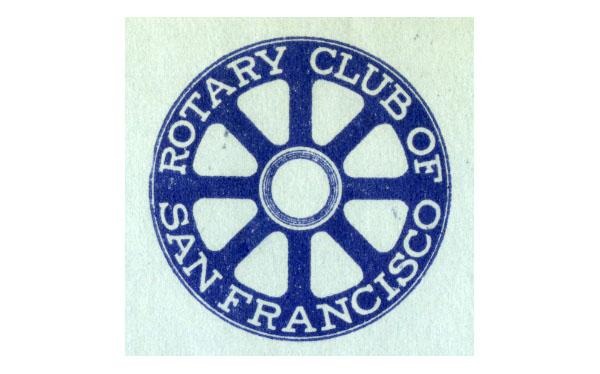 O emblema circular azul exibe a inscrição “Rotary Club of San Francisco”, em torno de um desenho de roda sobre um fundo claro.
