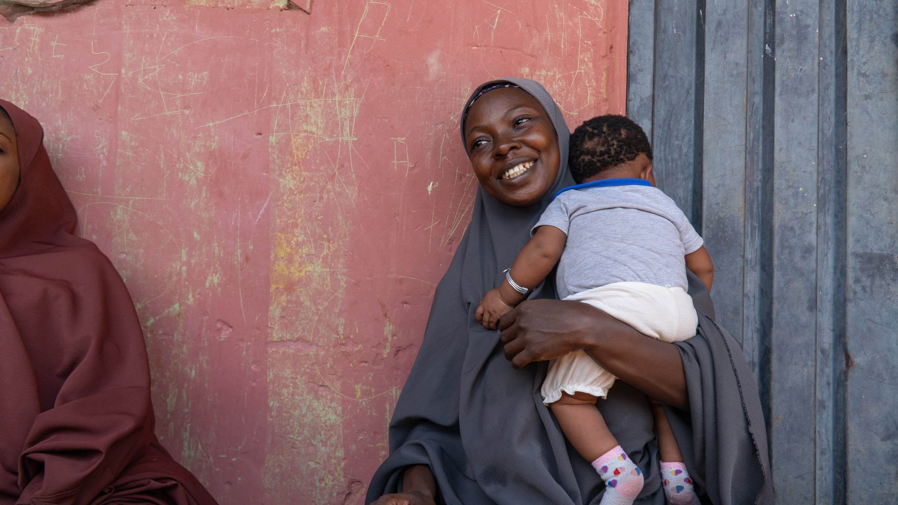 Nafisa Abubakar holds her child, Halima Ode, while waiting for care at a healthcare facility in Nasarawa, Nigeria, under a Rotary-supported maternal and child health initiative.