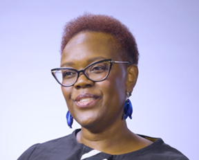 Person wearing glasses and earrings faces forward against a plain background.