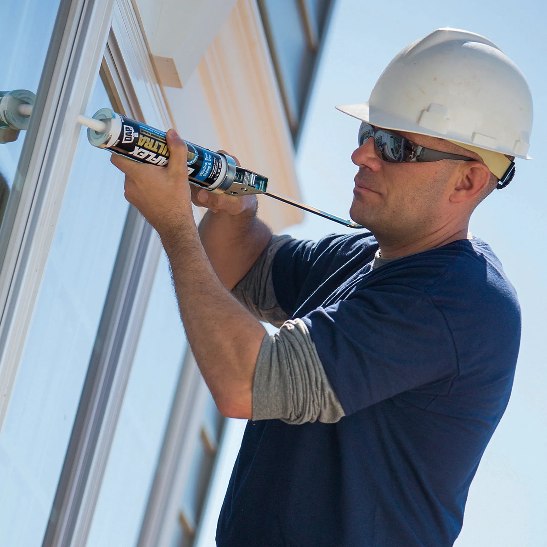 Contractor applying DAP Dynaflex Ultra sealant around an exterior window frame